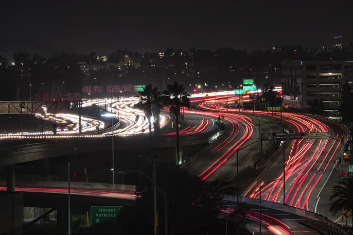 The view is of the downtown area and cars are driving down the high way