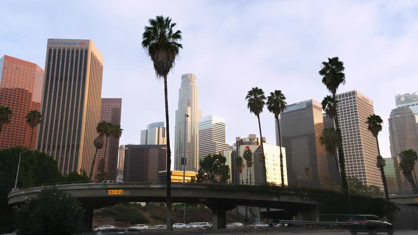 Skyscrapers loom over a motorway in a metropolis during the day