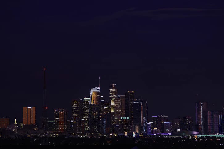 Time lapse of full moon rising over the skyline of the city at night