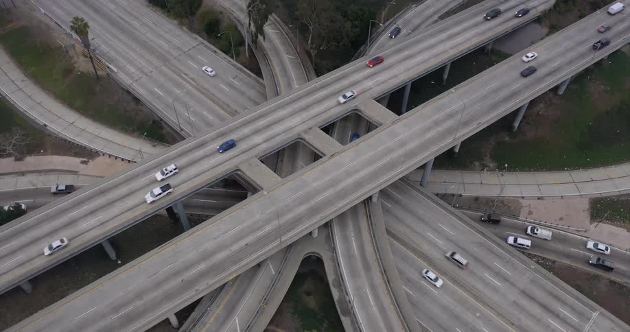 Traffic travels along a multilevel interchange on a highway during the day