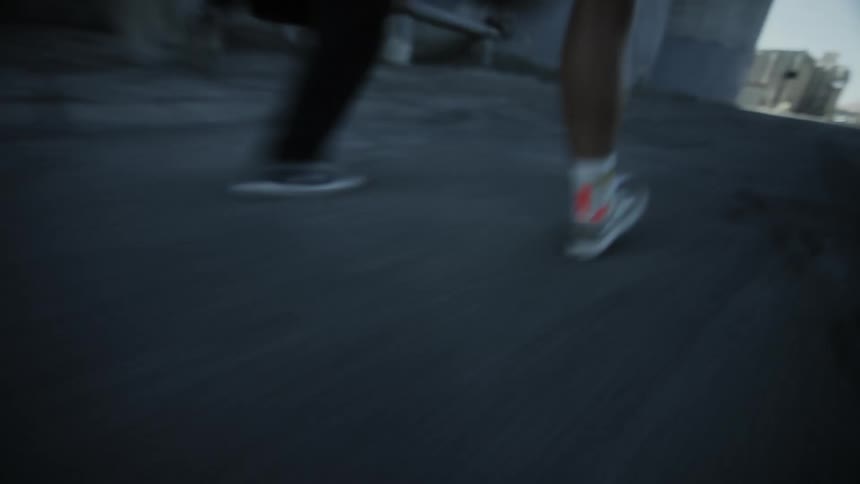 A close up shot of legs as two people start running along a street as if they are racing each other
