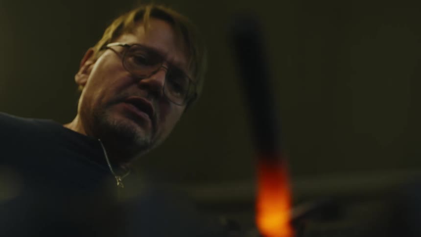 Blacksmith hammers on glowing molten bar