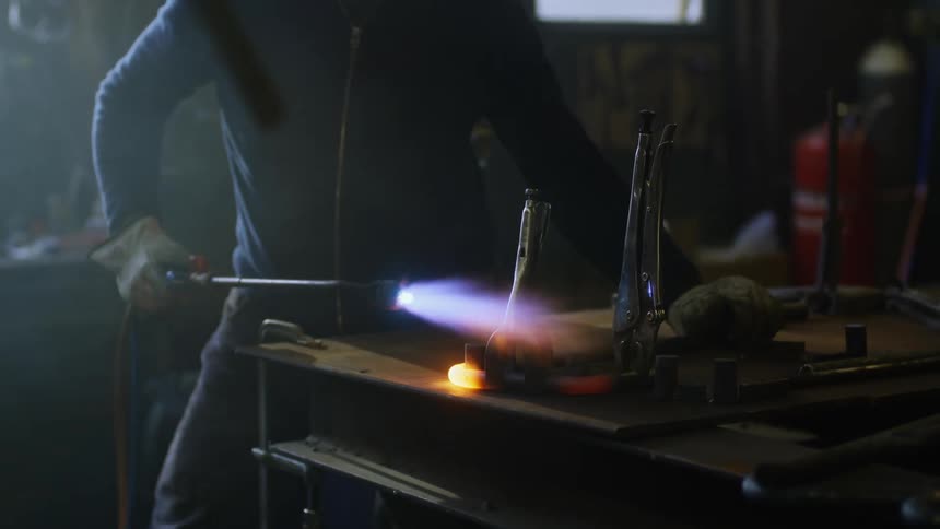 An older man is burning something inside of his house