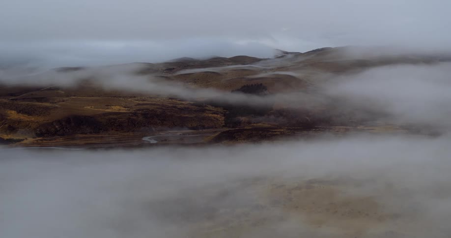 Aerial view of low clouds hovering over the hills at daytime