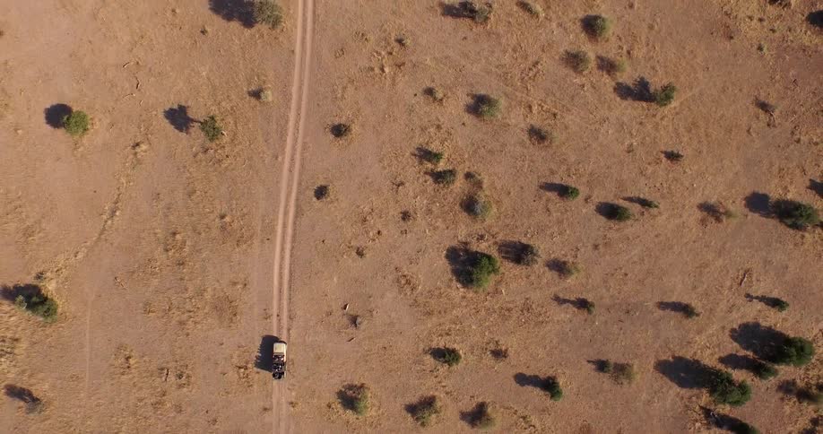 Aerial view of a jeep driving through the desert