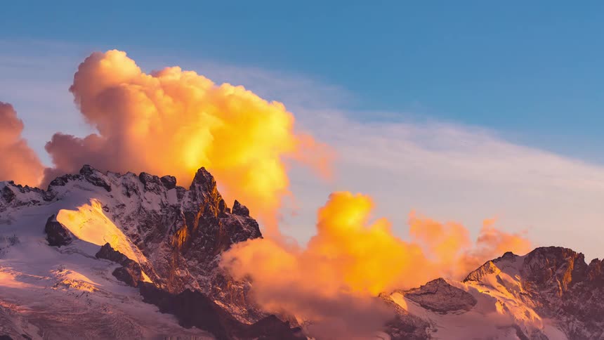 A time lapse of a mountain shows clouds hovering just overhead