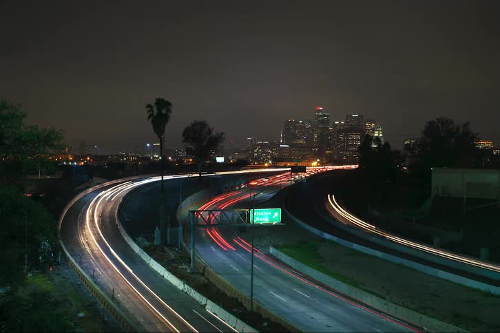 A time lapse of a multi lane highway at night with traffic traveling both directions