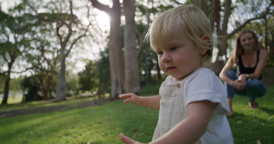 A mother watches her child walk
