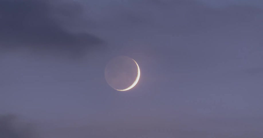 Time lapse of thin clouds rolling over the moon at evening