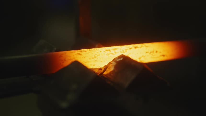 A person looking to touch a piece of metal