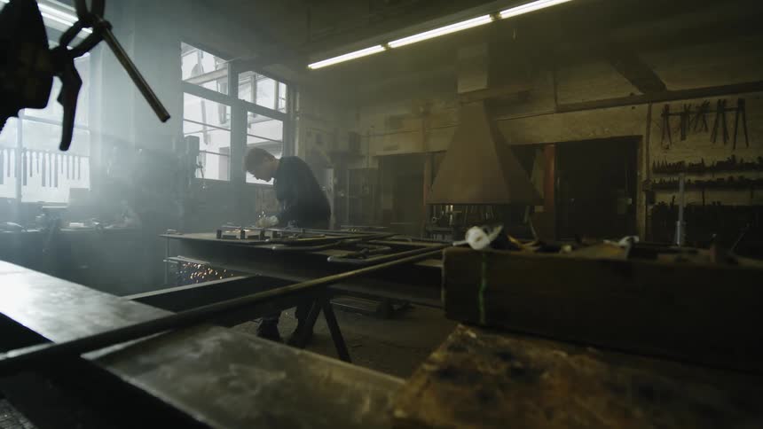 Sparks fly as a man welds metal in his workshop
