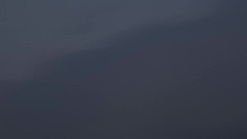 Clouds fade from pink to gray as moon glows over snowy mountain