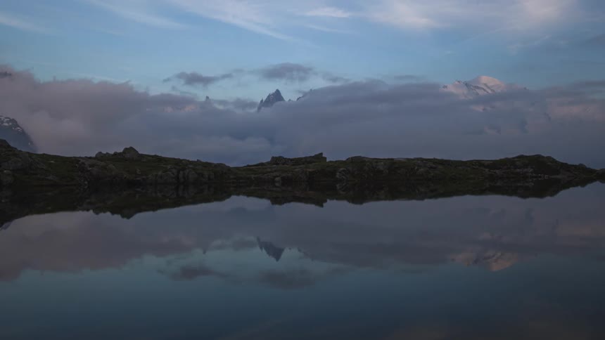 The mountains reflect in the lake water