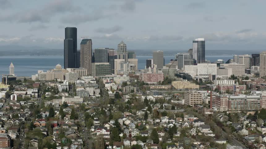 Moving past a city with many tall buildings by the water