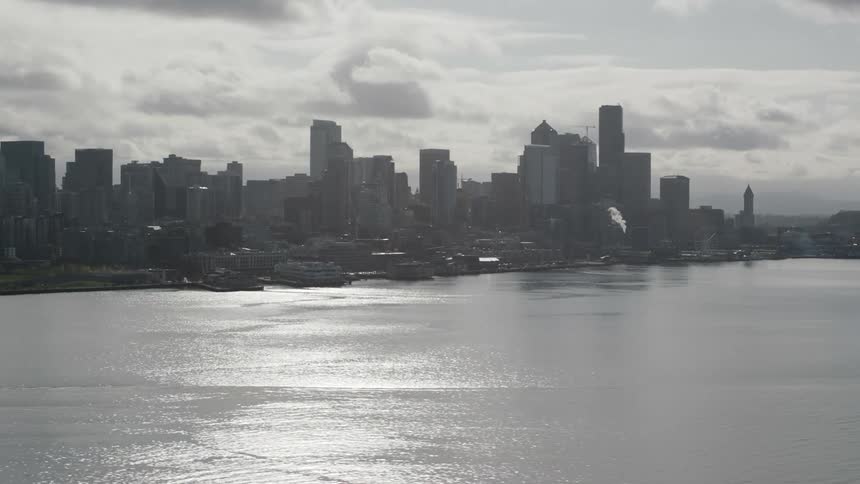 The sun shines on a river outside a metropolitan city