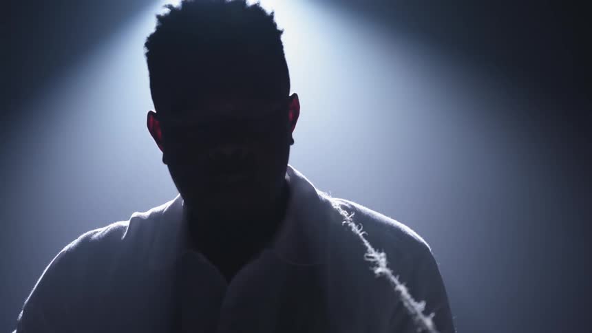 A man stands in front of a spotlight
