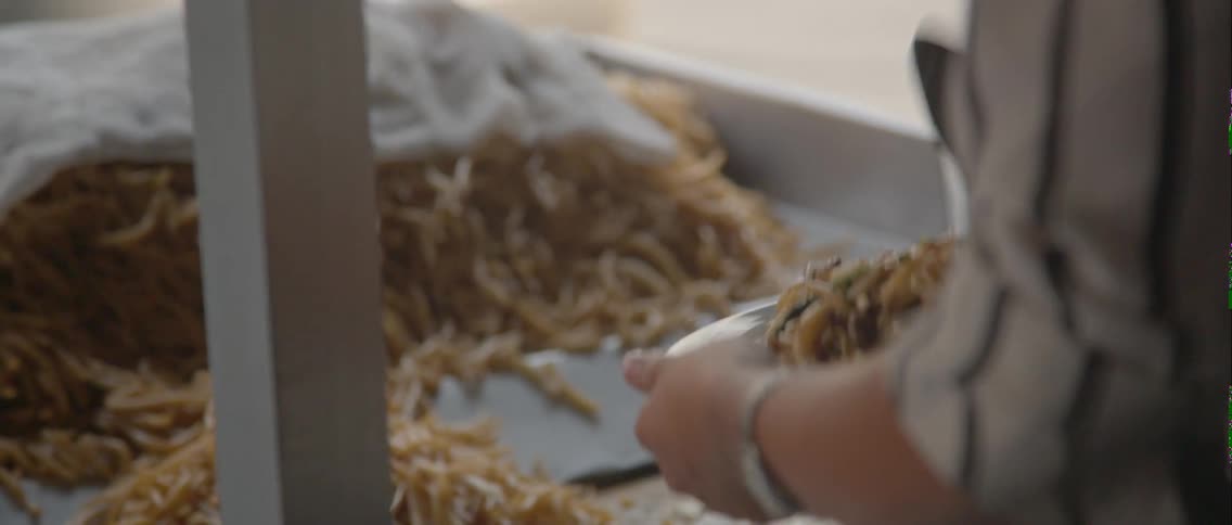 Close up of a fan and a person scooping food onto a plate