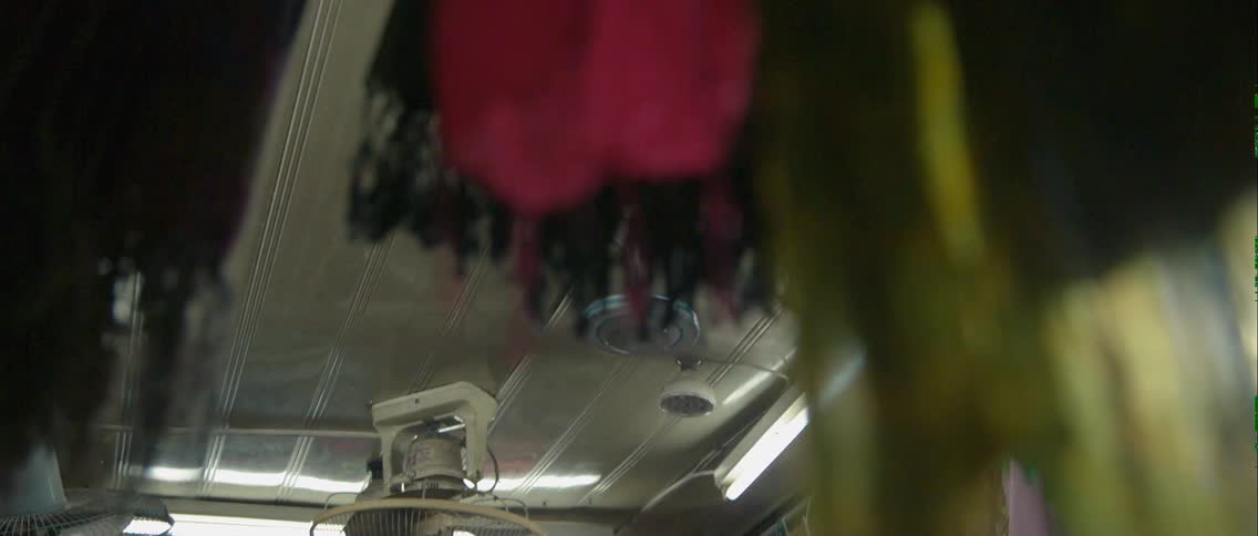 A fan spins overhead with clothes hanging all around