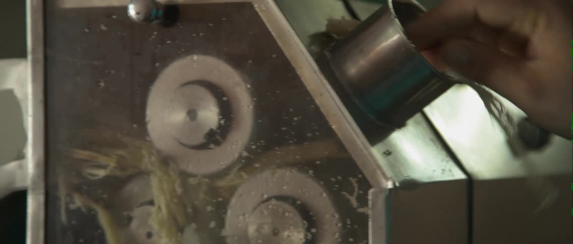 A person runs some food through a machine