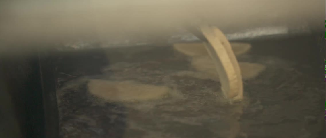 A person is flipping some food in oil