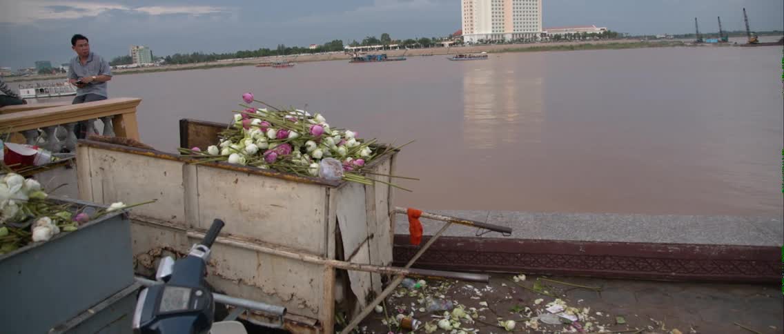 A bin of flowers is by this lake