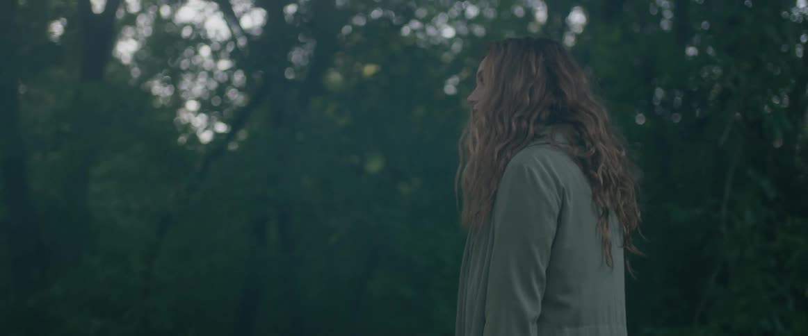 A woman walks in a forest
