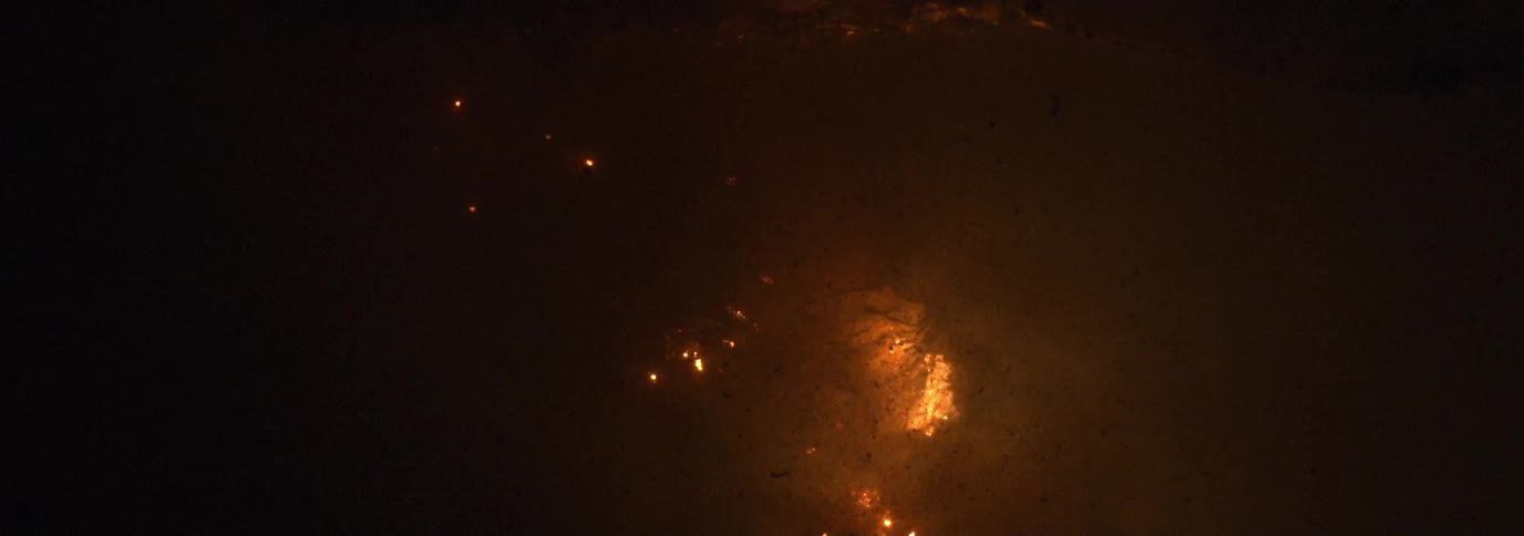 Brown white and gray colors that look like fire burning underwater with smoke and bubbles