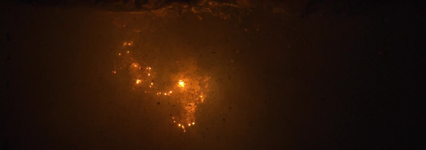 Orange and yellow fireworks explode in the night sky