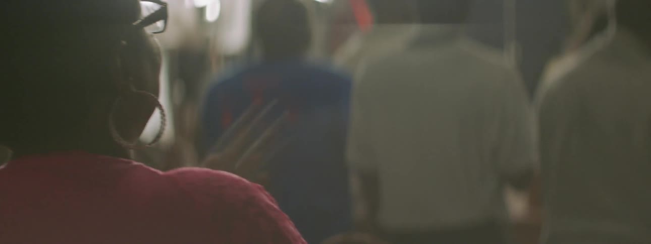 A person in glasses claps and moves back and forth