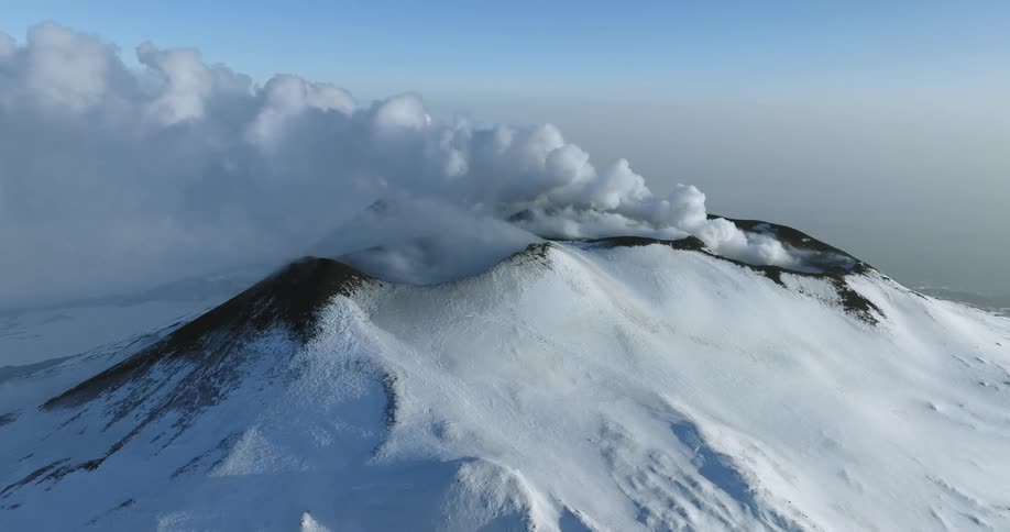 A heavy blanket of snow covers the peaks of a mountain range