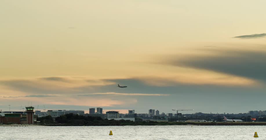 Commercial airplane flying low over the city skyline at evening