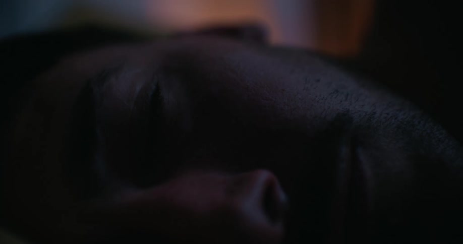 A man lies down on his side in bed