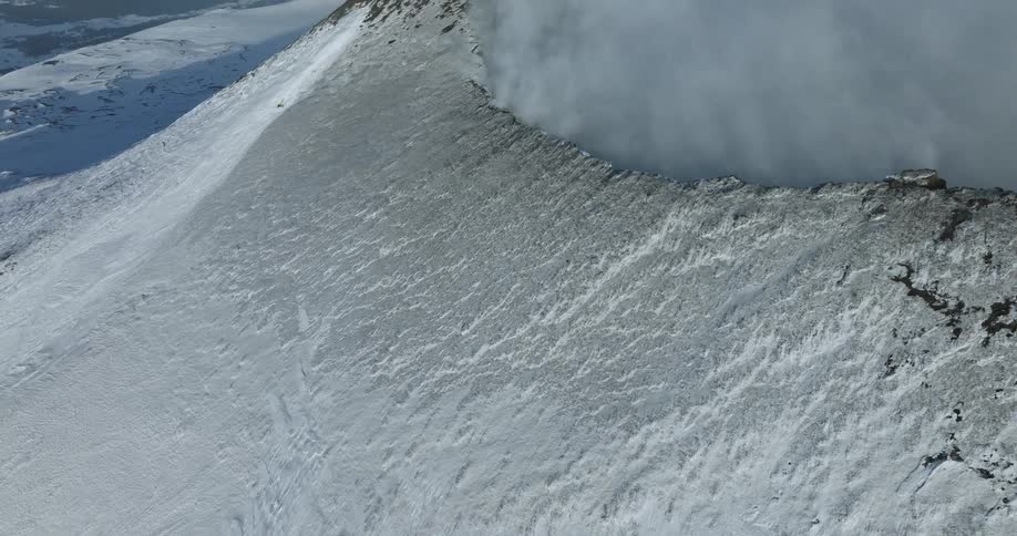 Aerial view of a snow covered mountain is displayed