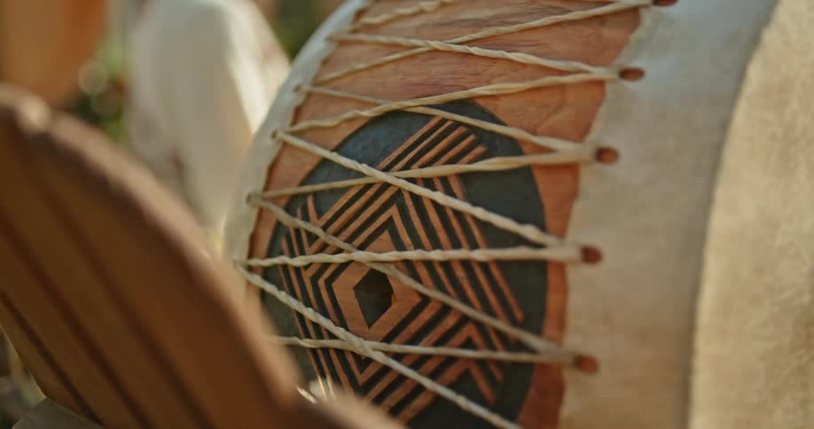 A handmade drum sits on a wooden chair