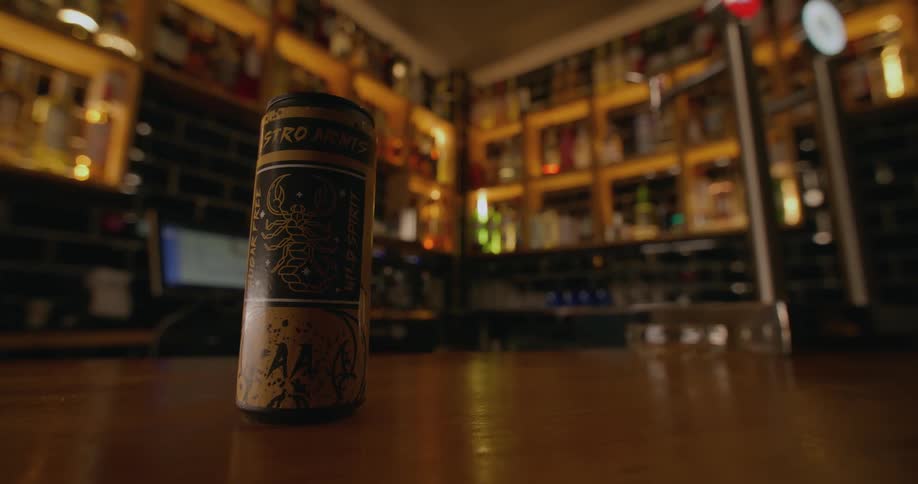 Person picks up can sitting on wooden surface in richly decorated shop