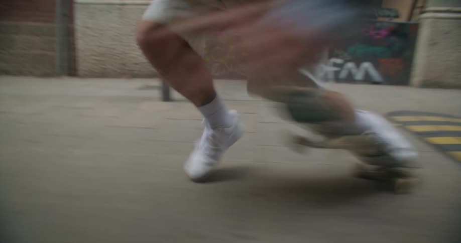 A man on a skateboard hops over a speed bump and falls off