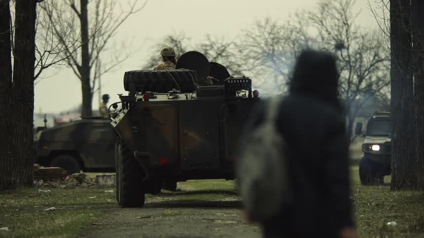 Military armored vehicles driving on a dirt road in the countryside