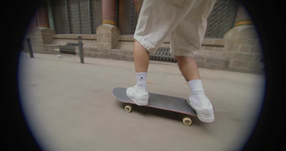 A skateboarder skates down the street of an old city