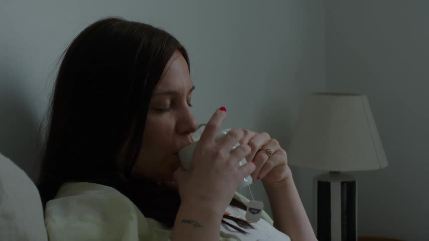 Man brings hot tea to his sick wife laying in bed at home