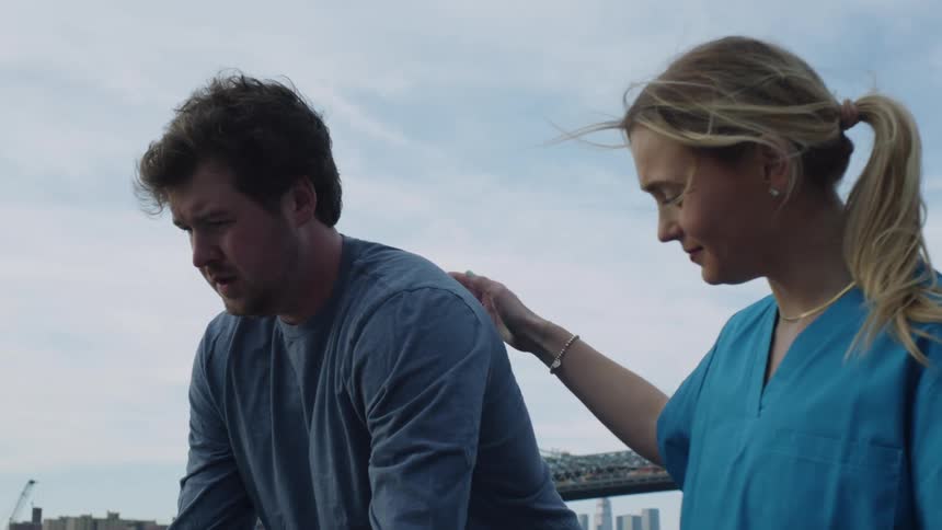A female physical therapist encouraging her male patient to walk with a walker outdoors
