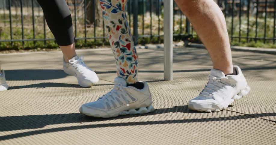 A person is walking slowly with a prosthetic leg