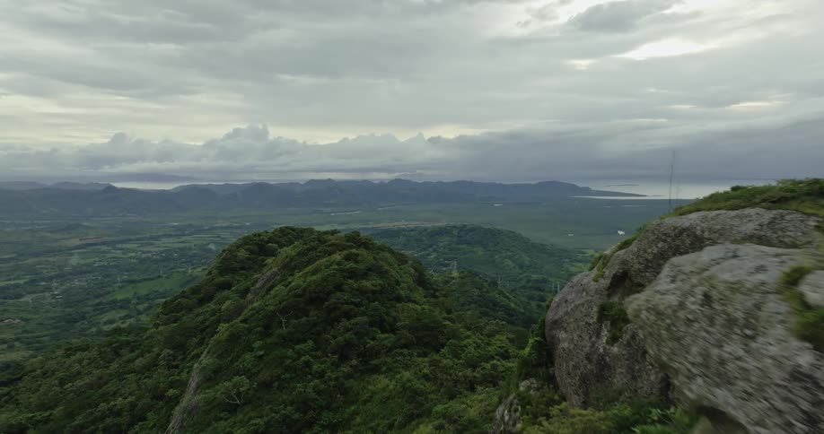 Trees and vegetation cover the peaks and side of a vast mountain range