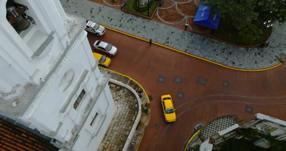 Aerial view of pedestrians and cars driving through a city