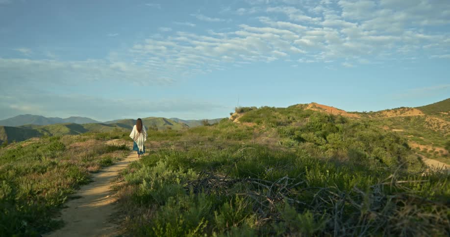 A woman is hiking outdoors during the spring time