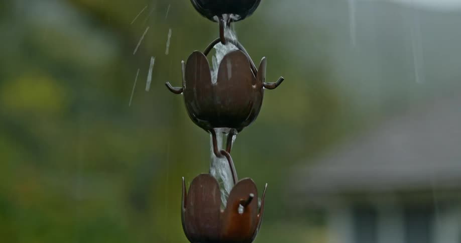 A close up of a tin gutter as water drains down it