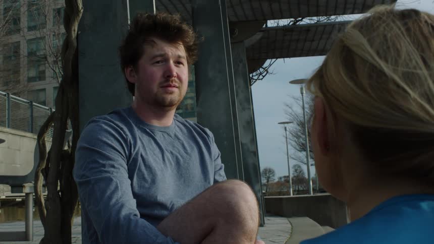 Female physical therapist and male patient taking a break and talking outside