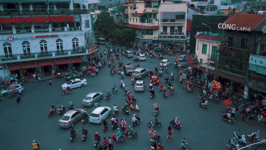 A busy urban street with cars and scooters