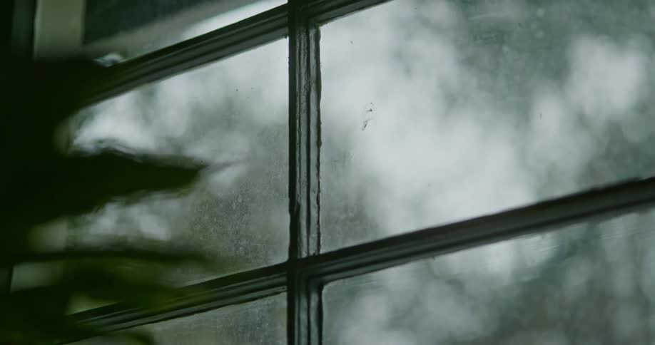 Close up view of a window during a rain storm is displayed