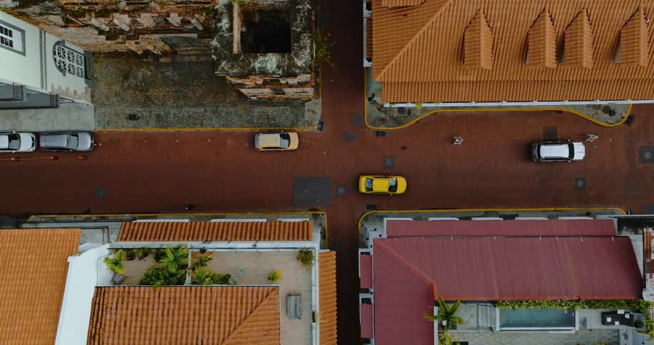 Aerial view of yellow car driving on the street in the city