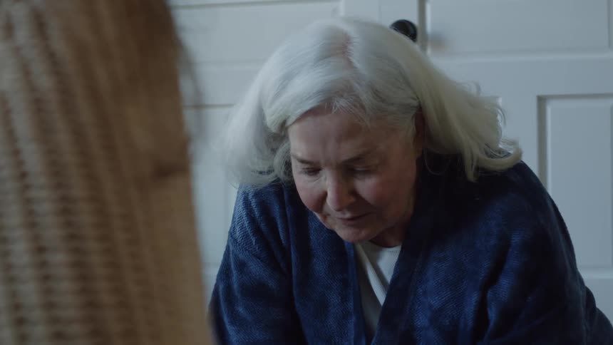 Woman with long white hair sitting on the living room floor assembling a puzzle